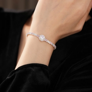 Detailed shot of a silver bracelet with pink and white zircon stones on a wrist
