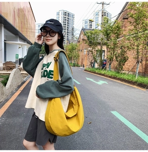 Detail of bright yellow crescent oxford bag with adjustable strap and casual urban style