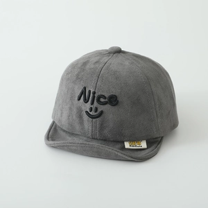 Detail of baby soft brim cap showing suede fabric texture and embroidered smiley face