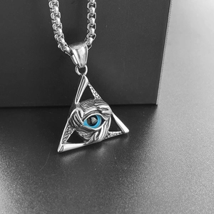 Close-up of vintage triangle Evil Eye pendant with blue eye and metal claw detail