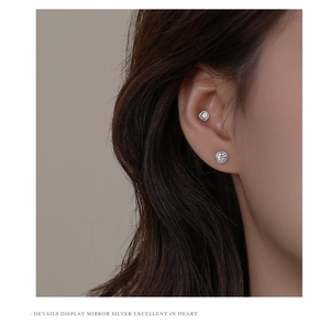 Close-up of S999 sterling silver stud earrings with sparkling round zircon on model