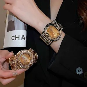 Détail du bracelet manchette torsadé avec cristal ambre et tressage en fil doré