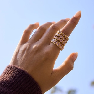 Ensemble de bagues empilables plaquées or 18k avec pierres roses sous un ciel bleu