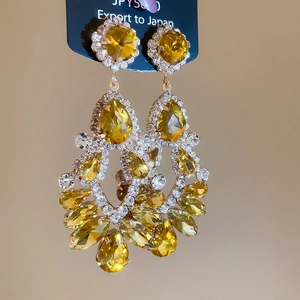Detailed view of layered amber crystal teardrop earrings with sparkling rhinestone accents
