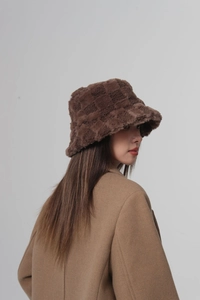 Close-up of the plush checkered texture on a brown and tan faux fur bucket hat