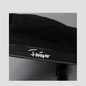 Detail of black JK uniform beret featuring white Forever embroidery and seam stitching
