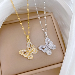 Detail of hollow butterfly pendants in gold and silver with sparkling crystal inlay