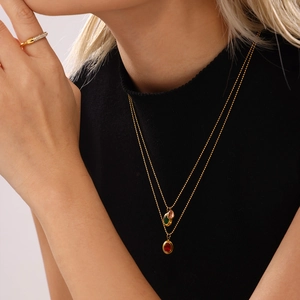 Goldene zweilagige Perlenkette mit bunten Edelsteinanhängern an einem weiblichen Model
