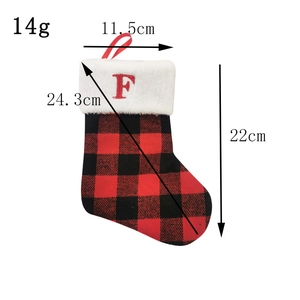 Detailed view of red and black plaid Christmas stocking with white trim and letter F