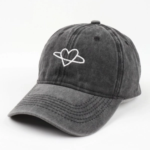 Detailed view of white heart embroidery on a vintage washed dark gray baseball cap