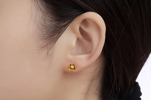 Detailed view of rose-shaped gold stud earring featuring a centered sparkling cubic zirconia