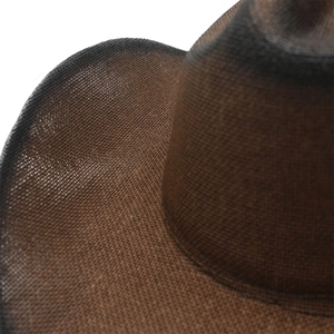 Macro detail of dark brown woven straw cowboy hat with vintage burnt edge texture