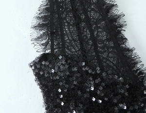 Détail rapproché du tissu en dentelle noire avec paillettes carrées sur la robe