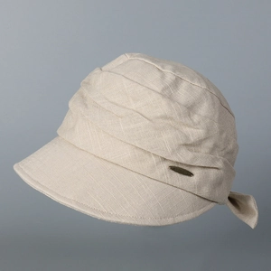 Close-up detail of beige pleated cotton linen sun hat with a small gold metal label