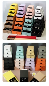 Stack of colorful kraft paper drawer jewelry boxes with satin pull ribbons and foam inserts