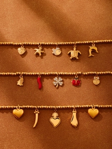 Nahaufnahme goldener Bambusarmbänder mit bunten Emaille-Anhängern und Zirkon-Details