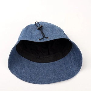 Detail of blue denim sun hat showing adjustable black drawstring and stitched inner lining
