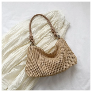 Close-up of hand-woven straw tote bag texture with premium leather shoulder strap