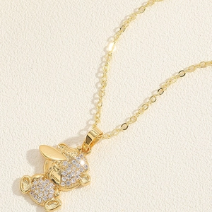 Macro shot of a gold teddy bear pendant necklace with white zircon pavé setting detail