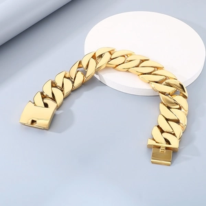 Detail of 43mm wide golden chunky Cuban link chain with polished finish and box clasp