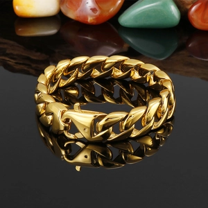 Bracelet gourmette dorée pour hommes avec fermoir mousqueton sur fond noir réfléchissant