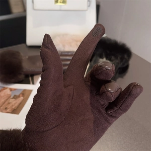 Detailed view of brown suede gloves showing touchscreen functional tips on thumb and index finger