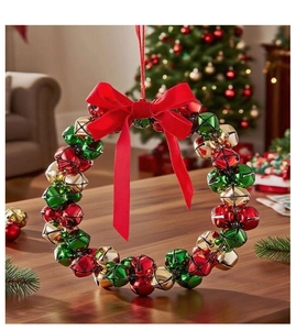 Detail of a Christmas wreath made of red, green, and gold bells with a red fabric bow