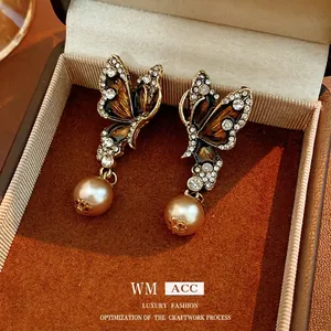 Vintage gold butterfly drop earrings with rhinestones and pearls in a velvet jewelry box