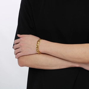 Bracelet gourmette dorée pour homme porté au poignet au style hip-hop et finition polie