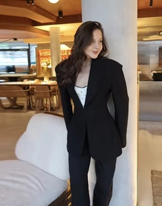 Detail of slim fit black suit jacket with lapels and matching tailored trousers