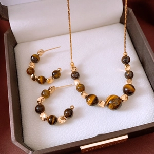 Detailed close-up of tiger eye necklace and earrings set in a luxury jewelry box