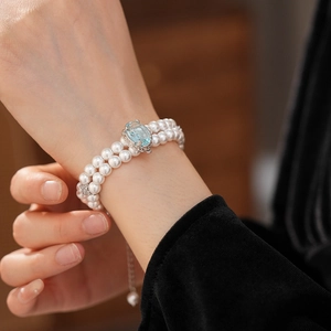 Détail d'un bracelet en perles double rang avec pierre bleue sur le poignet