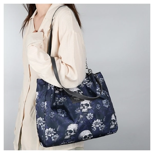 Detail of floral skull tote bag with chain strap and Maida brand label shown on model