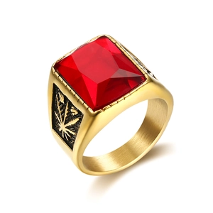 Detail of gold-plated stainless steel men's ring with rectangular red gemstone and leaf motif