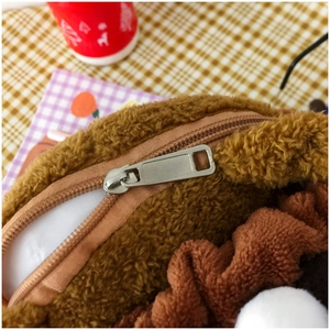 Close-up of the silver metal zipper detail on a soft brown plush dog crossbody bag