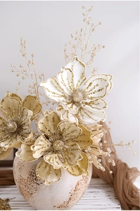 Close-up of artificial champagne gold magnolia with sequins in a vintage ceramic vase