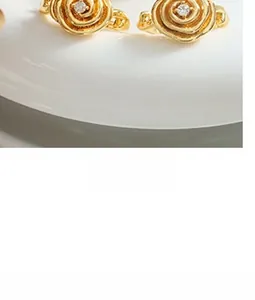 Detailed close-up of 18K gold rose earrings with white zircon center and layered petals