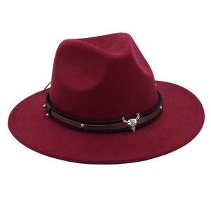 Close-up of burgundy wool fedora with brown leather rivet band and silver bull skull charm