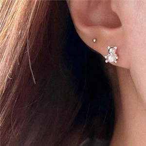 Minimalist 925 sterling silver bear stud earrings with pearl on a female model