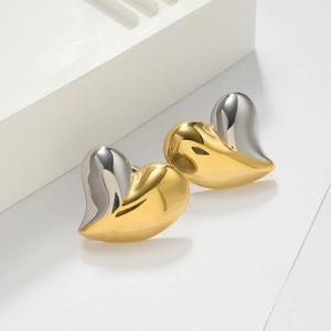 Detail of 18K gold plated heart earrings in a two-tone gold and silver metallic design