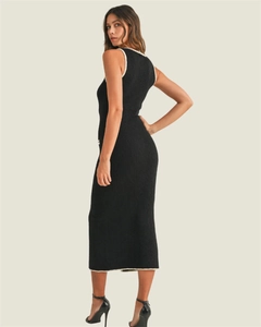 Detail of slim fit black knitted dress with white contrast trim and side slit hemline