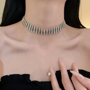 Close-up of a wide silver choker necklace with multi-layer rhinestones on a model
