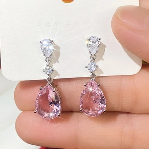 Detailed macro view of pear-shaped pink cubic zirconia drop earrings on a jewelry card