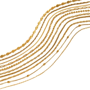 Collection of layered gold plated necklaces including cable, ball, and anchor chain styles
