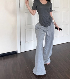 Detail of dark grey V-neck slim t-shirt paired with light grey high-waist joggers