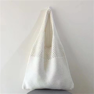 Detail of white hollow-out knitted tote bag showing mesh texture and woven craftsmanship