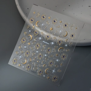 Détail d'autocollants 3D dorés pour ongles motif lune et œil de protection