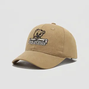Detailed close-up of khaki cotton baseball cap with embroidered bear and Pleasure text