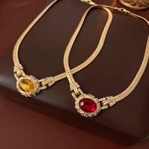 Detail of vintage snake chain necklaces with oval red and yellow crystal pendants
