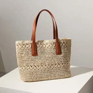 Large beige woven straw tote bag with brown leather straps for beach holidays